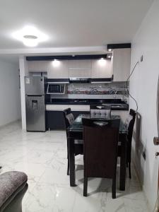 a kitchen with a table and chairs and a refrigerator at PYMABET in Huancavelica