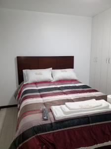 Una cama con una manta y un mando a distancia. en PYMABET, en Huancavelica