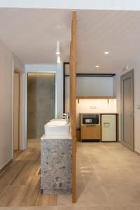 een badkamer met een witte wastafel en een aanrecht bij Alboro seaside suites in Parga