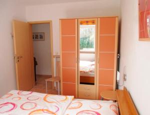 a bedroom with orange walls and a bed at Ferienhaus am Plauer See - a55880 in Lenz