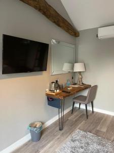 a desk in a room with a television and a chair at The British Queen, Meldreth in Meldreth +12 photos