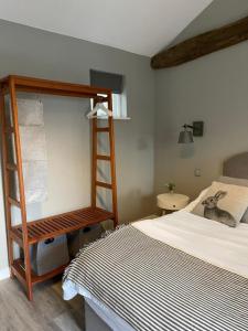 a bedroom with a bed and a wooden bunk ladder at The British Queen, Meldreth in Meldreth
