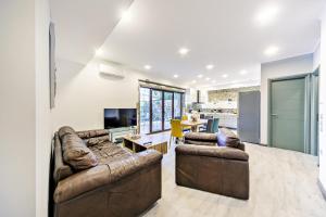 a living room with two brown leather couches at Filia Stone Villa in Gouvia