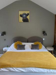 a bedroom with a large bed with a yellow blanket at The British Queen, Meldreth in Meldreth