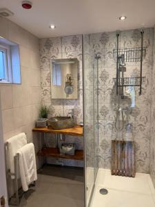 a bathroom with a shower with a glass door at The British Queen, Meldreth in Meldreth
