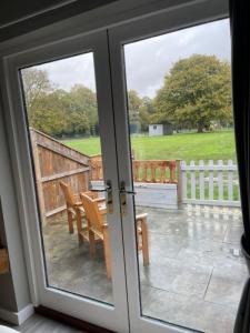 a sliding glass door with a view of a yard at The British Queen, Meldreth in Meldreth