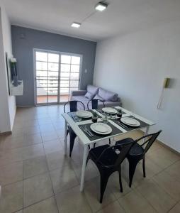 Una mesa de comedor y sillas en una sala de estar. en Home Zafiro II, en Santa Fe 8 fotos más