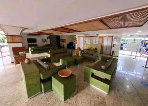 a lobby with green couches and tables at Barreirinhas Gran Lençóis Flat Residence Mandacaru 506 Particular in Barreirinhas