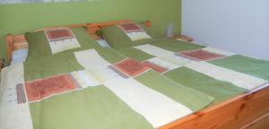 a bed with green and white quilts on it at Ferienwohnung am Plauer See - a55900 in Alt Schwerin
