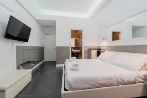 a white bedroom with a bed and a flat screen tv at WE LOVE ROMA Guest House in Rome