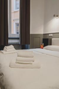 two beds with white towels on top of them at WE LOVE ROMA Guest House in Rome