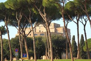 a building behind a bunch of trees in a park at WE LOVE ROMA Guest House in Rome