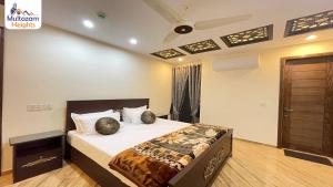 a bedroom with a bed with two pillows on it at Multazam Heights, DHA Phase 8 - 3 Bedrooms Luxury Apartments in Lahore