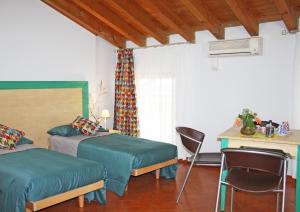 een slaapkamer met 2 bedden, een bureau en een tafel bij Agriturismo Fiorbello 