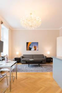 a living room with a couch and a chandelier at Parkview Boutique Apartments in Vienna
