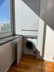 a washing machine in a room with a window at Sunset Guest House in Matosinhos