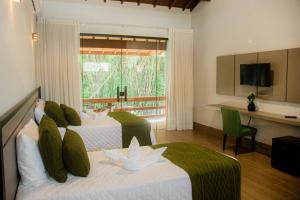 a hotel room with two beds and a balcony at Pousada Saint Diniz in Monte Sião +82 photos