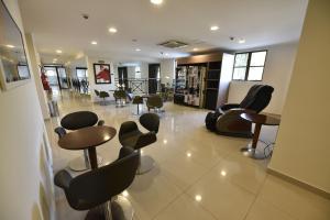 a salon with chairs and tables in a room at Hotel Rainha dos Apóstolos in Aparecida