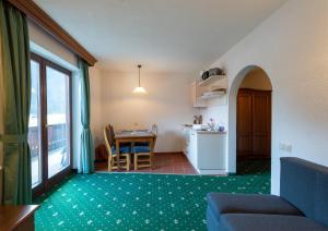 ein Wohnzimmer mit einem Tisch und einer Küche in der Unterkunft Ferienwohnungen Hirschen in Bichlbach