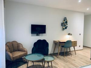 a living room with two chairs and a table and a television at VILLA MADY Adultes Only in Andernos-les-Bains