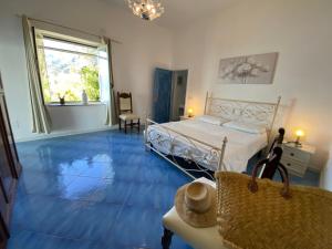 a bedroom with a bed and a blue floor at IL PROFUMO DEI FIORI SUITE in Praiano