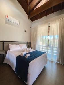 a bedroom with a bed with two towels on it at Pousada Saint Diniz in Monte Sião