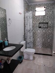 a bathroom with a toilet and a sink and a shower at Aconchego Standart in Angra dos Reis
