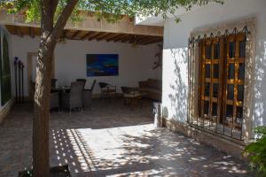 eine Terrasse mit einem Tisch, Stühlen und einem Baum in der Unterkunft Finca del Rocio in Parras de la Fuente