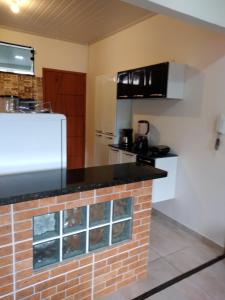 - une cuisine avec un comptoir en briques dans une pièce dans l'établissement Aconchego Standart, à Angra dos Reis