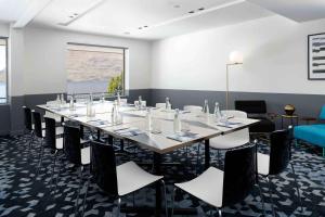 une salle de conférence avec une grande table et des chaises dans l'établissement Rydges Lakeland Resort Queenstown, à Queenstown