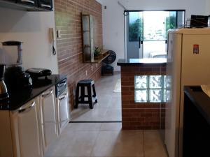uma cozinha com um frigorífico e uma parede de tijolos em Aconchego Standart em Angra dos Reis