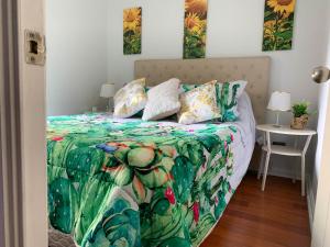 1 cama con edredón y almohadas verdes en Depto Metro Plaza de Armas (1 dormitorio 1 baño), en Santiago
