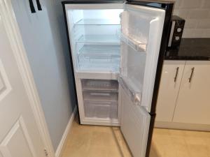 an empty refrigerator with its door open in a kitchen at Gorgeous 1-Bed Apartment in Wetwang Driffield in Wetwang