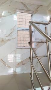 uma escada que leva a uma janela num quarto com mármore branco em Flat Marimbá - Duplex em Porto de Galinhas