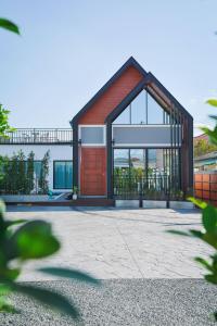 duży dom z czerwonymi drzwiami i szkłem w obiekcie Baan Salmon Pool Villa Chiang Mai w mieście Mae Rim