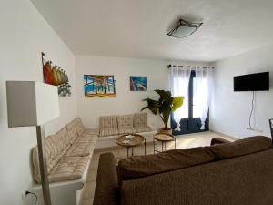 een woonkamer met een bank en een tafel bij CALIMA Holiday House in Caleta de Sebo