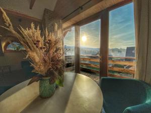 a vase of flowers sitting on a table in front of a window at Dziejba Leśna Apartamenty &Spa in Jaworki