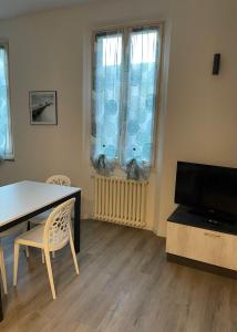 sala de estar con mesa de comedor y TV en Un balcone sul centro storico, en Reggio Emilia