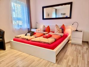 a bed with orange pillows on it in a room at FeWo 2,4,5,6 Altstadt - Am grossen Garten in Dresden