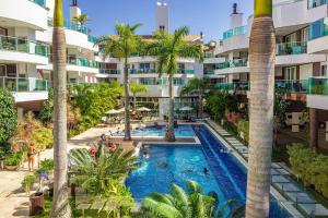Una vista aérea de la piscina de un resort con palmeras. en Boulevard 310D - Excelente Cobertura com Jacuzzi Privativa em condomínio de luxo no centro de Bombinhas - Piscina - Jacuzzi - Academia - Portaria 24h., en Bombinhas
