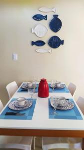 uma mesa de jantar com pratos e pratos em Flat Marimbá - Duplex em Porto de Galinhas