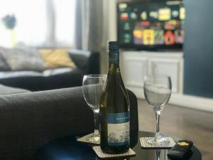 eine Flasche Wein und zwei Gläser auf dem Tisch in der Unterkunft 3 bedroom house in Preston close to M6 & M55 in Preston