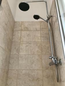 eine Dusche mit Duschkopf und Fliesenboden in der Unterkunft 3 bedroom house in Preston close to M6 & M55 in Preston