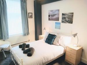 a bedroom with a bed with two pairs of shoes on it at Modern comfy 2-Bedroom flat in St Helens in Saint Helens