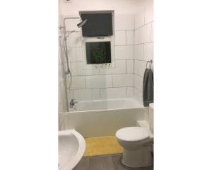 ein Badezimmer mit einer Badewanne, einem WC und einem Waschbecken in der Unterkunft Central Wigan welcoming Townhouse sleeps up to 6 in Wigan