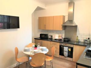 cocina con mesa y sillas en Central Wigan welcoming Townhouse sleeps up to 6, en Wigan