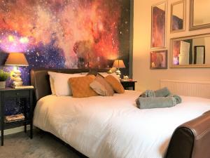 1 dormitorio con 1 cama con una pintura en la pared en Central Wigan welcoming Townhouse sleeps up to 6, en Wigan