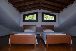 two beds in a room with two windows at Οροφομεζονέτα σε συγκρότημα κατοικιών-Μοναδική θέα in Poligiros