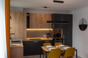 a kitchen with a table and chairs in a kitchen at Apart B&V in Braşov