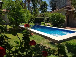 a swimming pool in a yard with red flowers at La Deolinda in Funes